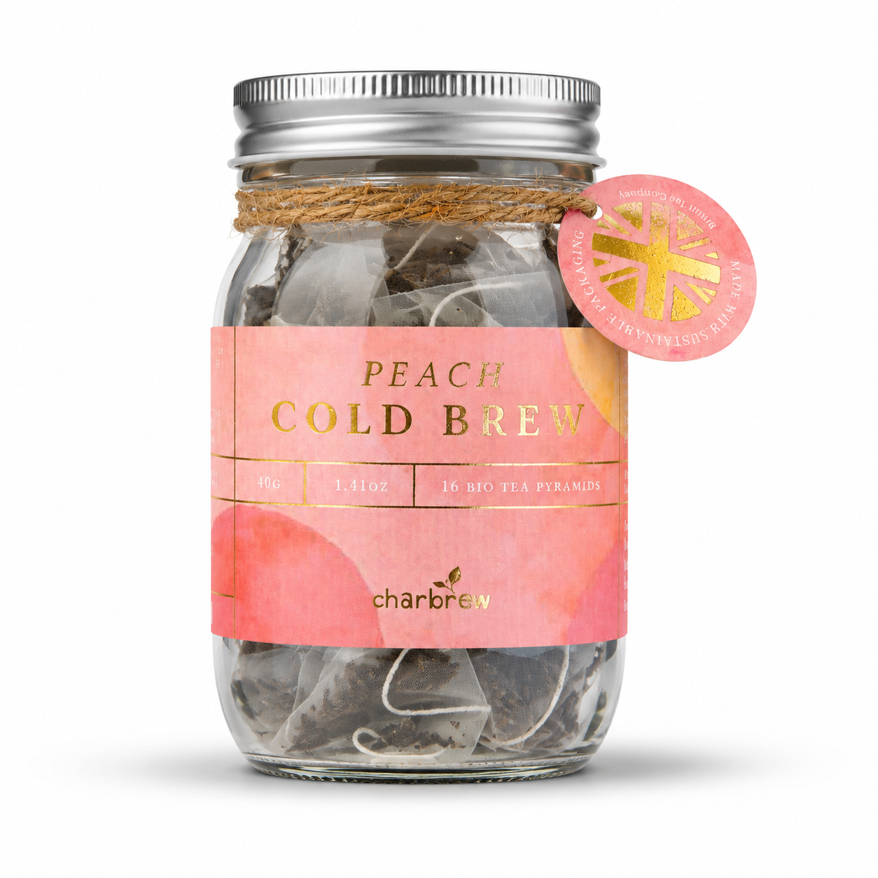 A glass mason jar filled with peach cold brew teabags, featuring a pink label with gold lettering, a silver metal lid, and a pink circular tag on the side. perfect for picnics, alfresco dining, dinner and garden parties, gifts , non alcoholic summer alternative.